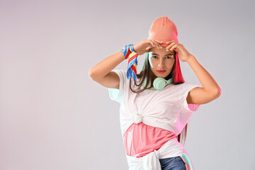 Beautiful hip-hop dancer in hat on light background