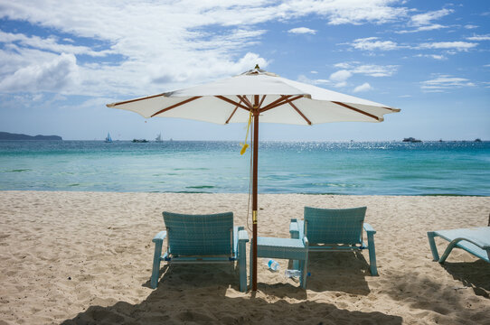 Umbrella with two lounge chairs on the beach, Boracay, Philippines