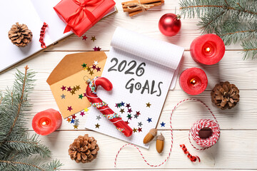Notebook with 2026 goals and Christmas decor on white wooden background