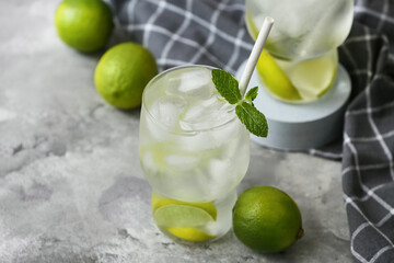 Glasses of lime infused water with mint leaves on grey background, closeup
