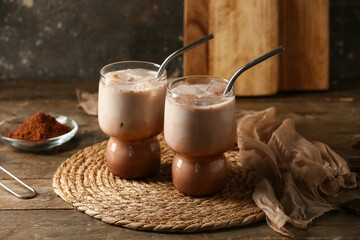 Glasses of cold cocoa drink on wooden table