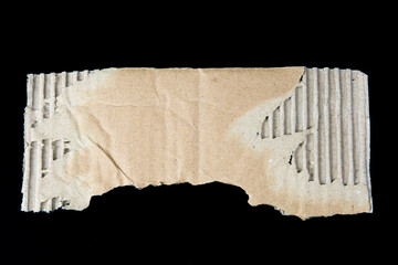 Ripped cardboard paper scraps. Piece of torn cardboard isolated on black background. damaged carton top view.  recycled cardboard.