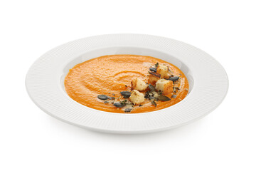 Plate of delicious pumpkin cream soup with seeds and croutons isolated on white background, closeup