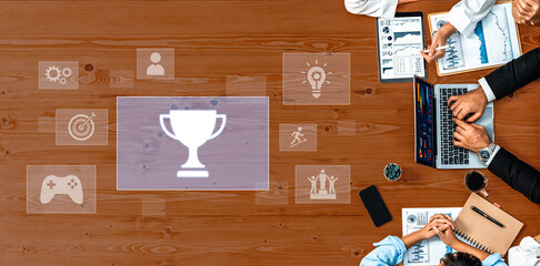Aerial view of a business meeting showcasing hands engaged in discussion around a wooden table with...