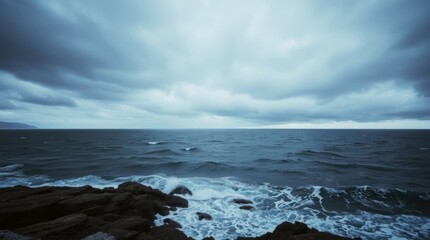 Fototapeta premium Dramatic Sea: The turbulent sea under a brooding sky, waves crashing against rocky shoreline. The atmosphere is heavy with the promise of a storm, evoking both awe and introspection.