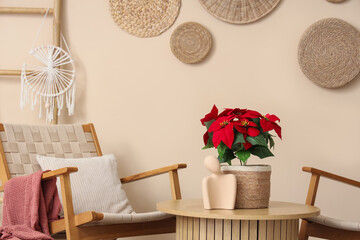 Christmas plant poinsettia with statuette on table in living room