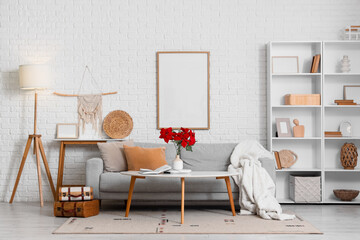 Interior of modern living room with Christmas plant poinsettia on table and sofa