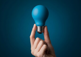 Hand holding a blue light bulb against a dark blue background