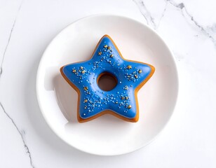 Overhead shot of a star-shaped pastry with blue glaze and sprinkles on a white plate