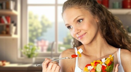 Happy young woman cooking healthy food in modern kitchen