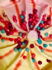 Yellow and pink ice cream swirls with colorful round sprinkles.