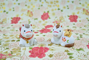 可愛い馬の置物と和柄の背景の年賀状素材