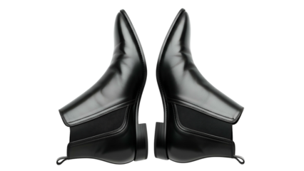 Symmetrical composition features two polished black leather ankle boots against a dark backdrop