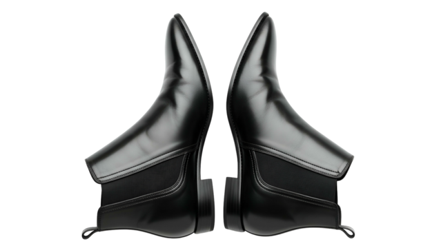 Symmetrical composition features two polished black leather ankle boots against a dark backdrop