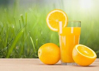 Orange juice with fresh fruits in farming background.