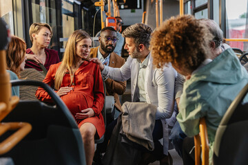 Passengers helping pregnant woman in public bus