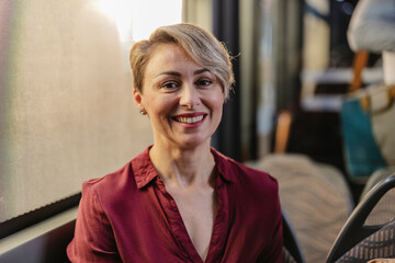 Smiling woman commuter traveling by public bus