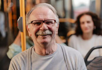 Senior man smiling happily riding public bus