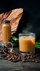 A refreshing iced coffee drink with milk foam and roasted coffee beans.