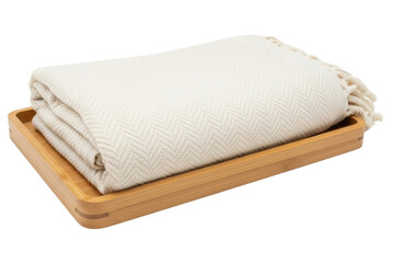 Folded cream colored herringbone wool throw blanket in bamboo tray isolated on transparent background