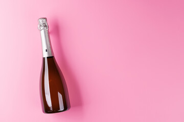 A stylish champagne bottle with elegant glasses on a soft pink background