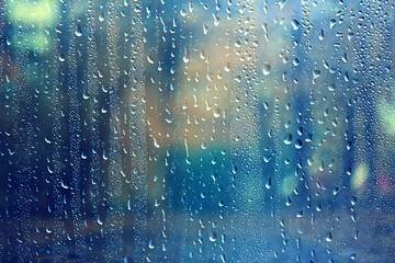 Wet glass, rainy weather, autumn background, rain in the park, blurred abstract backdrop