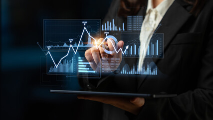 A business professional engages with interactive financial data on a tablet, surrounded by modern graphics and metrics in a sleek office setting, highlighting analysis and strategy. Scalp