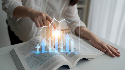 A person points at a financial growth chart over an open book, illustrating the concept of data...
