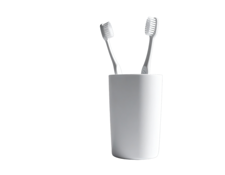Two toothbrushes stand in a white octagonal cup