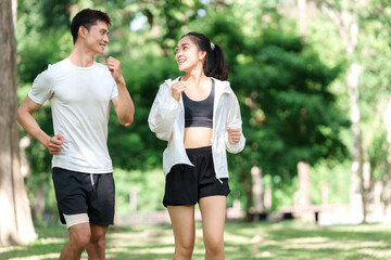 Young couple jogging together in green park © Phimwilai