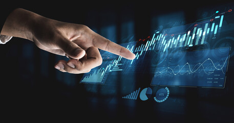 A futuristic hand interacting with a digital touchscreen displaying financial graphs and data...