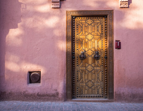 traditional moroccan door set in pink adobe wall