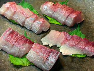 脂ののったブリの刺身と大葉の盛り付け