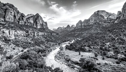 Black and white mountain valley landscape with river, trees, cliffs, and roads under a cloudy sky