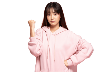 Asian Young woman in pink hoodie showing determined gesture with fist raised and confident expression