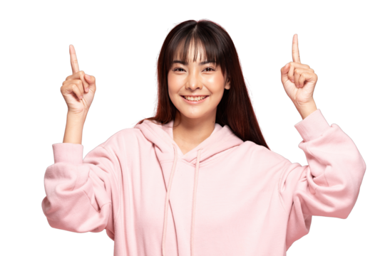 Asian Smiling young woman with hoodie pointing upward with both hands, cheerful expression, casual portrait, studio background