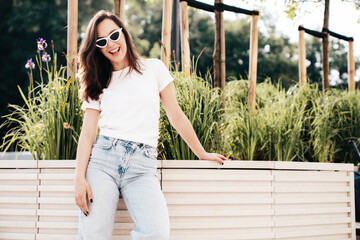 Young beautiful smiling hipster woman in trendy summer white t-shirt and jeans clothes. Sexy...