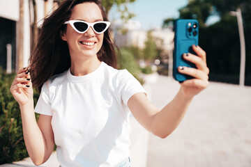 Young beautiful smiling hipster woman in trendy summer white t-shirt and jeans clothes. Sexy...