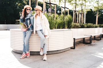 Two young beautiful smiling hipster female in trendy summer clothes. Carefree women posing in the...