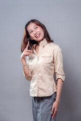 Cheerful Asian Woman Pointing Up with Bright Smile