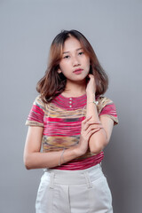 Elegant Asian Woman with Calm Expression in Colorful Outfit