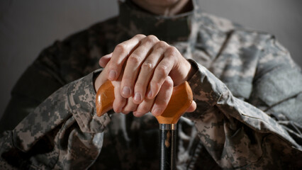 Soldier in camouflage uniform holding a cane, symbolizing veteran support and resilience