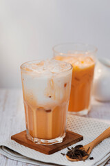 Thai tea with milk in a glass jar placed on a wooden table