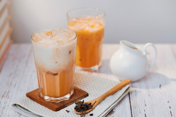 Thai tea with milk in a glass jar placed on a wooden table