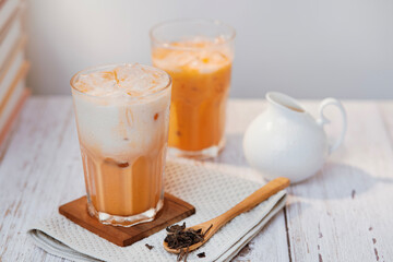 Thai tea with milk in a glass jar placed on a wooden table