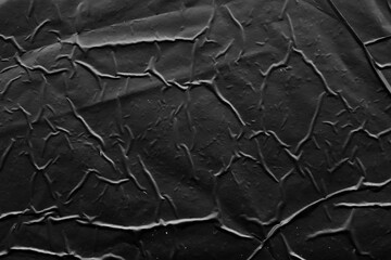 black crumpled and creased plastic poster texture background