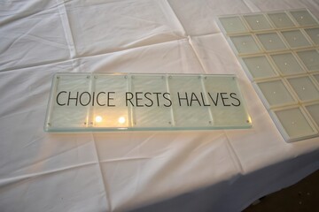 Transparent tile with words Choice Rests Halves on white fabric