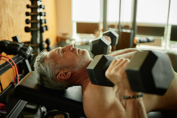 Middle Aged Man Lifting Dumbbells during Strength Training Workout