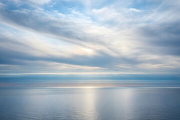 Soft light shimmering through clouds over tranquil horizon