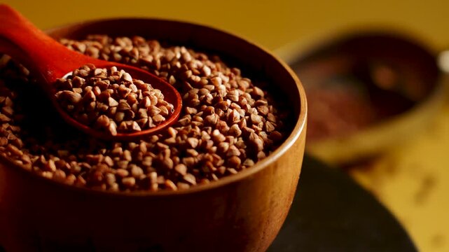 Buckwheat groats in a wooden bowl with a spoon during an afternoon setup